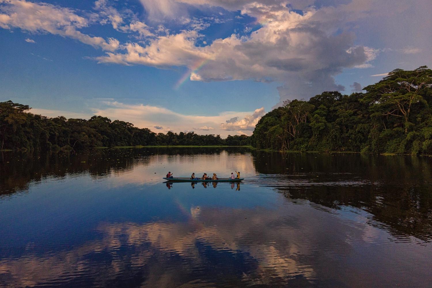 people on boat in amazon rainforest
